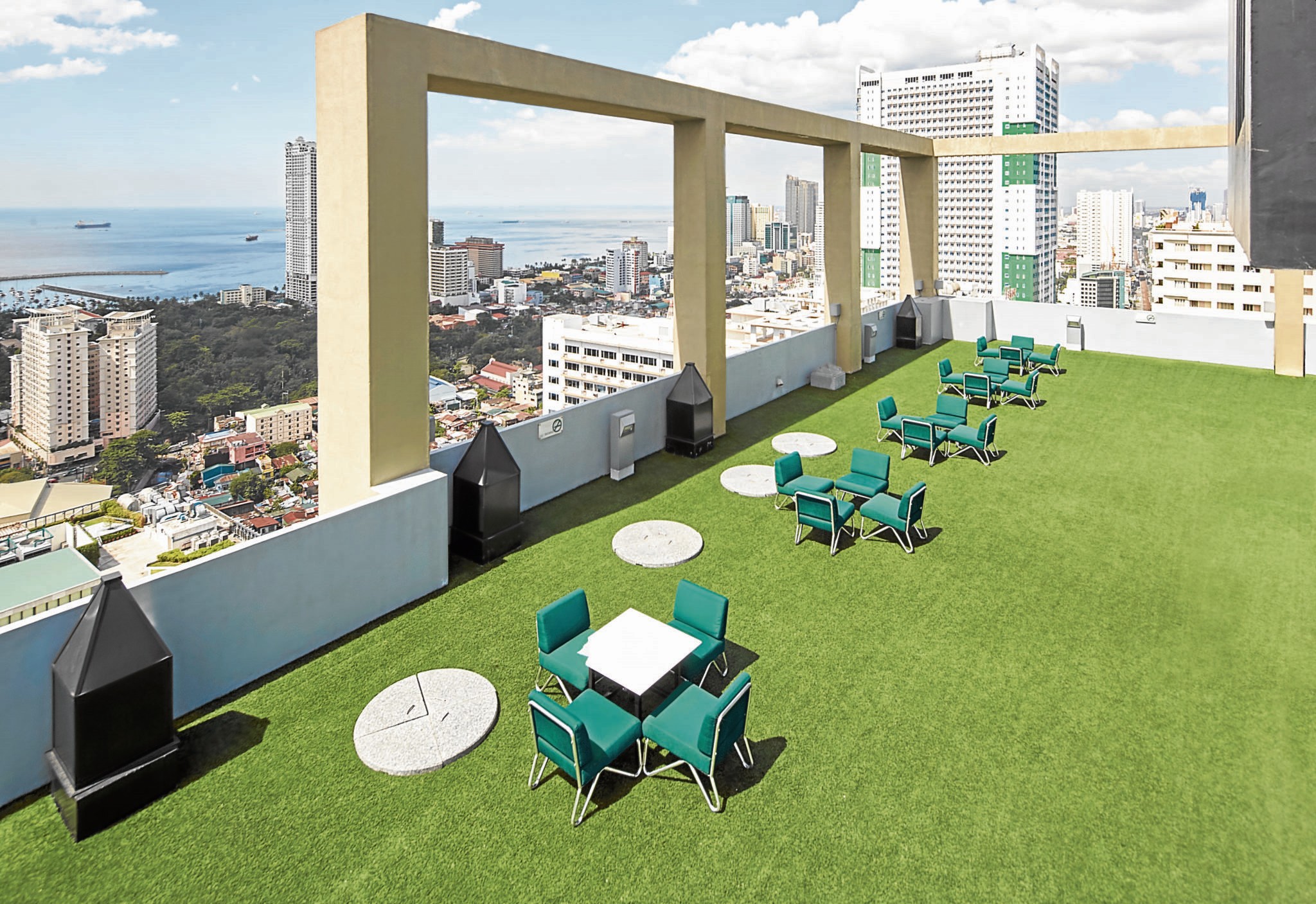 There is an artificial green grass floor beneath emerald green chairs on the sky deck area.