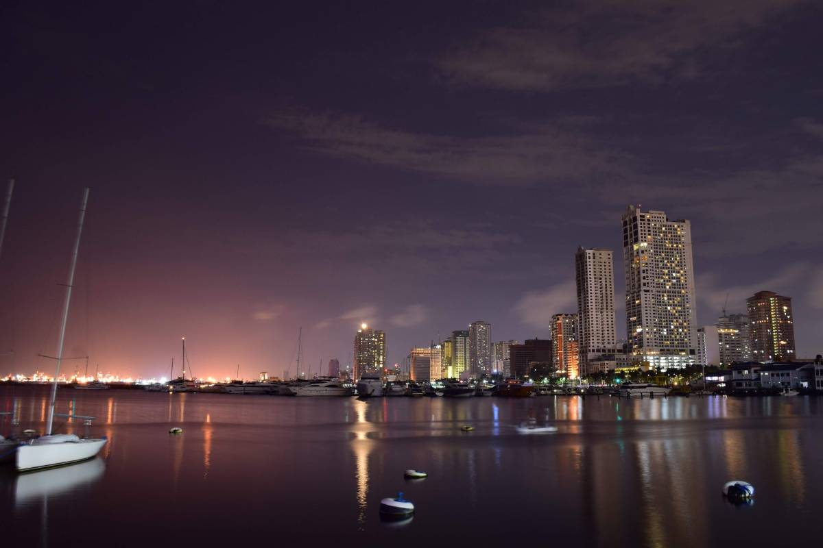 Night shots of city lights capture tall buildings surrounded by massive amounts of water.