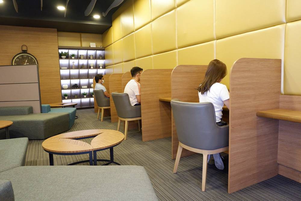 Students' cubicles are provided for personal space in a study area made of wooden upholstery materials.
