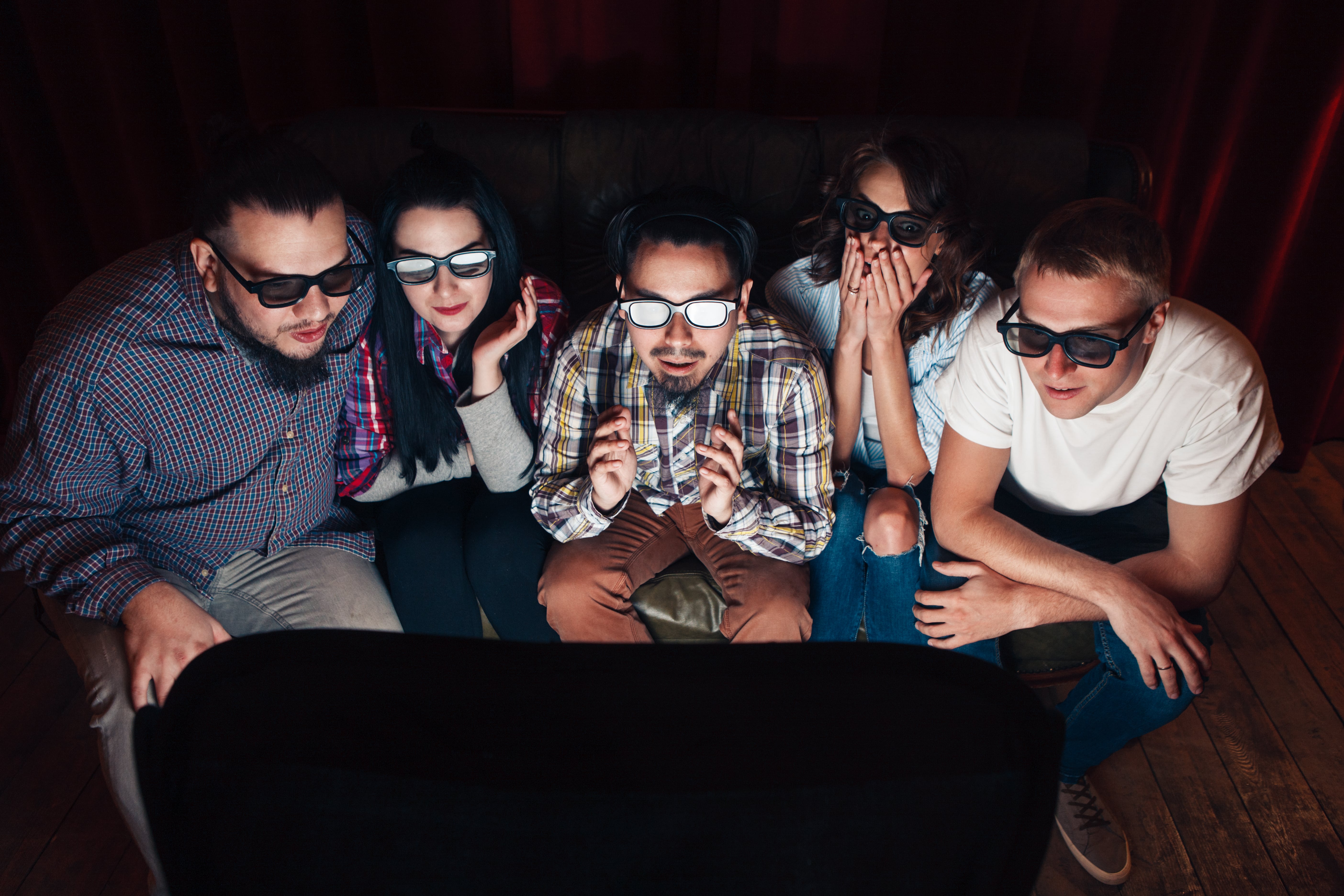 young people in 3d glasses watching movie on couch 