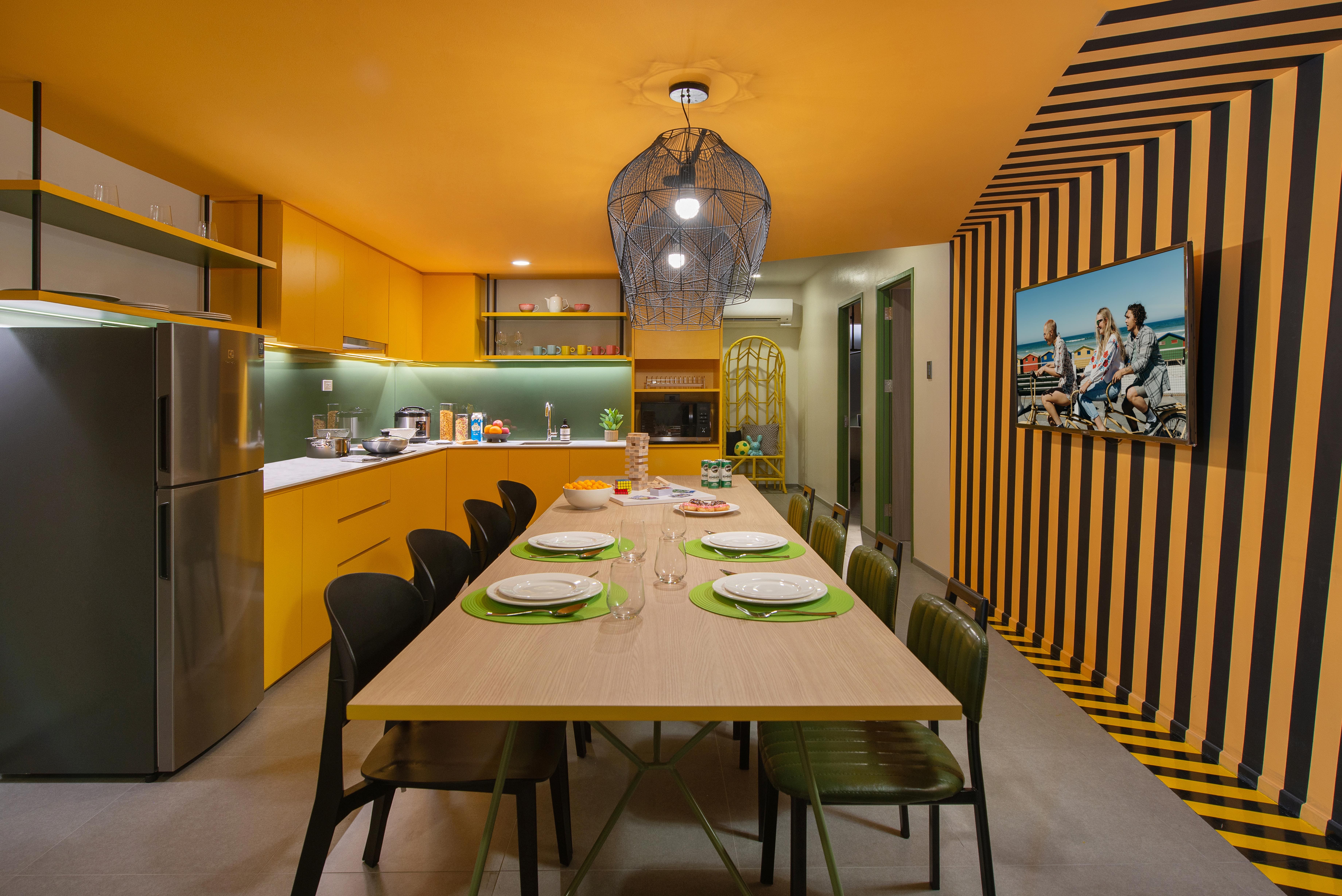 a dining table in lyf Malate with green plates and chairs in a kitchen